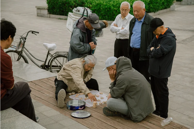 A group of people in Tianjin, China play a game together in a park, showing community activities.