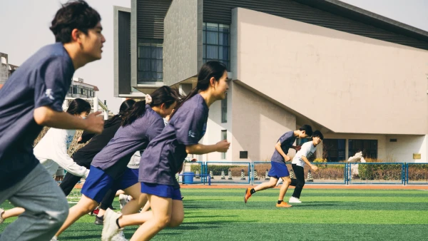 mixed gender students running sprints during physical education class with the best american curriculum in tianjin china