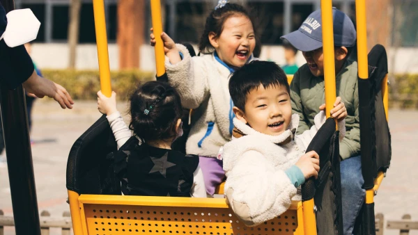 four young students in yellow swing outside tianjin international school early childhood center