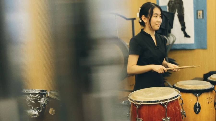 female student playing drums at tianjin international school learning the art of music