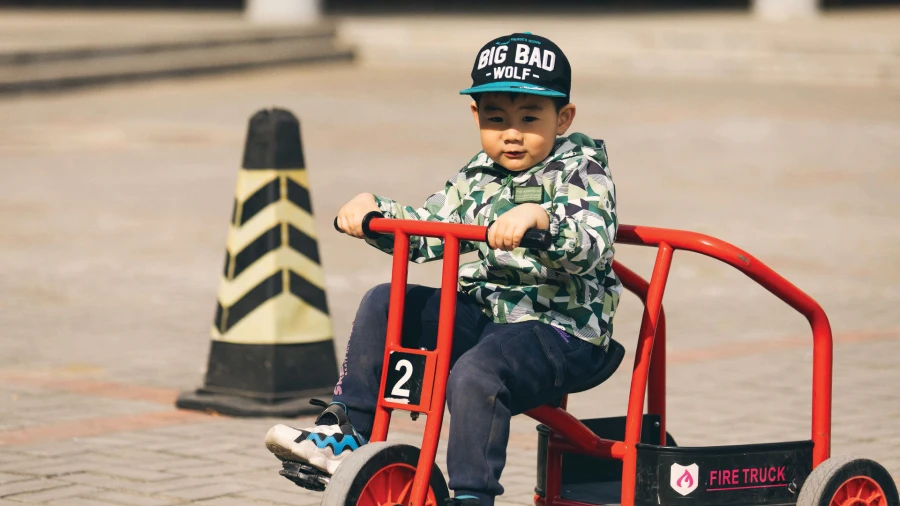 young male student at tianjin international school learning physical fitness with red bicycle